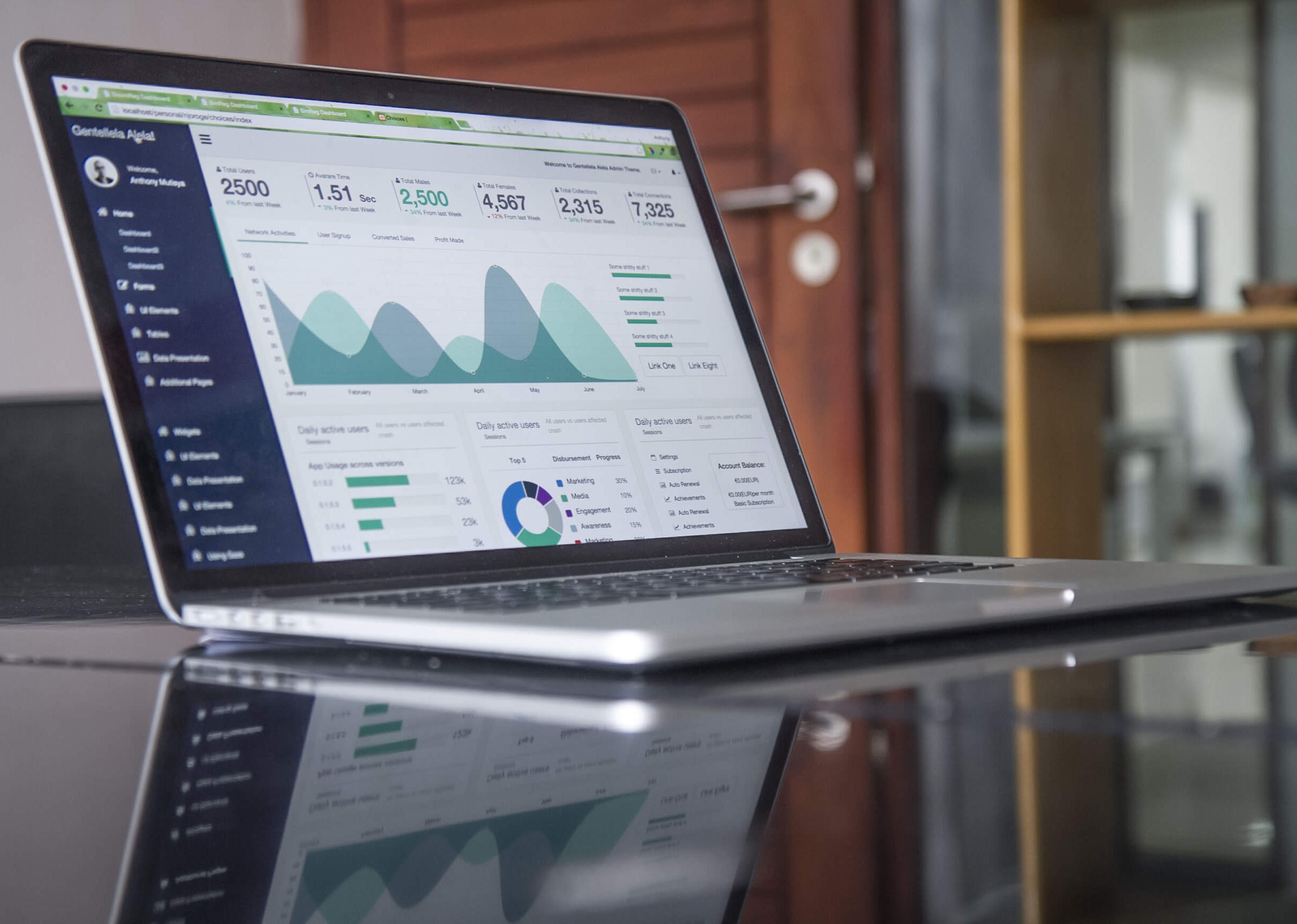 Laptop with statistics on a glass table